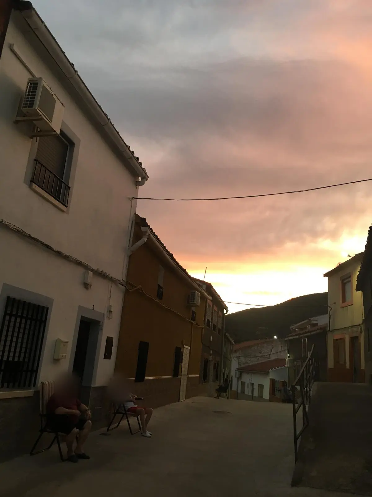 Vecinos tomando el fresco en una calle de El Hoyo